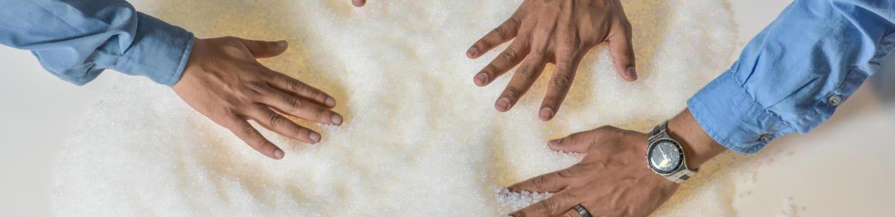 Hands spreading Saudi Aramco produced chemical products